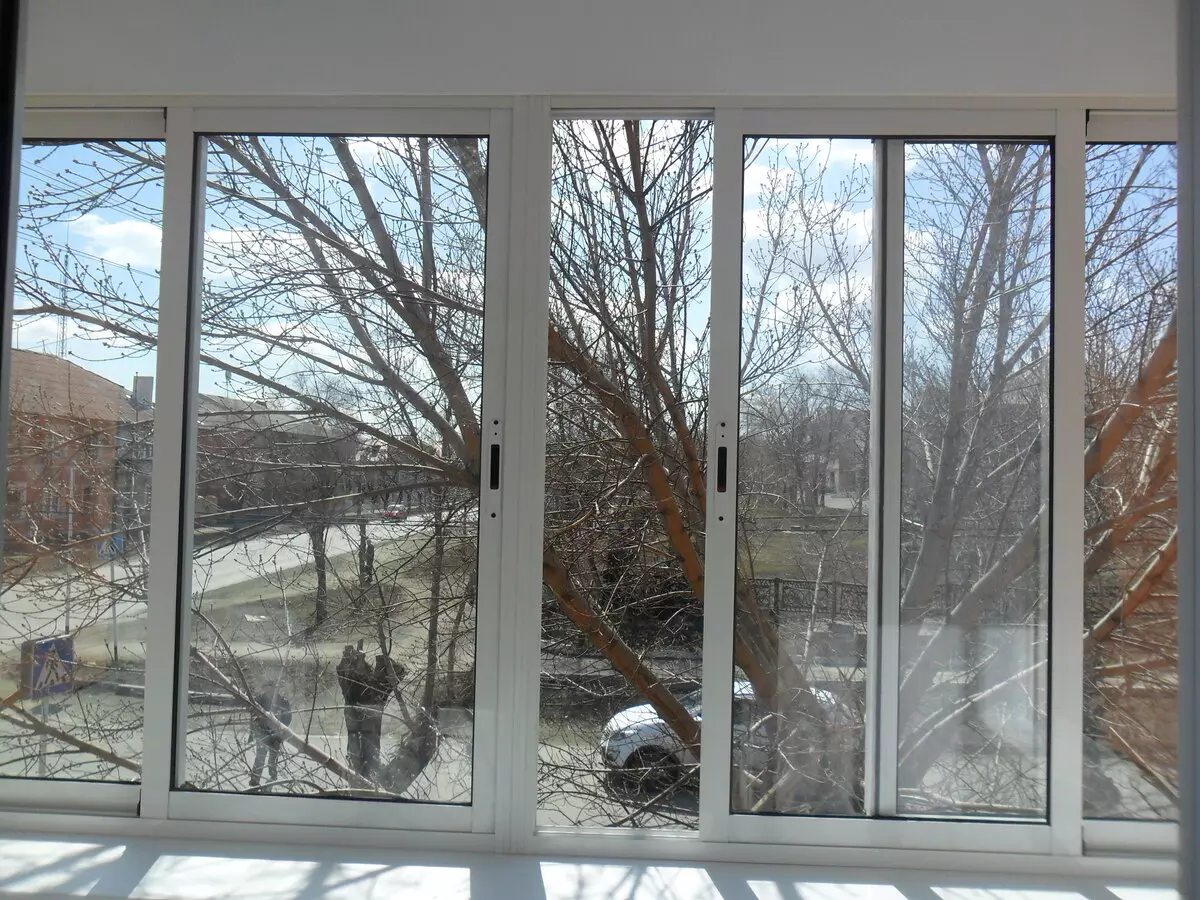 Balkoni kaca oleh profil aluminium (51 foto): Ciri-ciri Balkon Aluminium Bingkai, jenis tingkap kaca yang sejuk dan hangat, sistem cahaya dan bengkak 10026_17