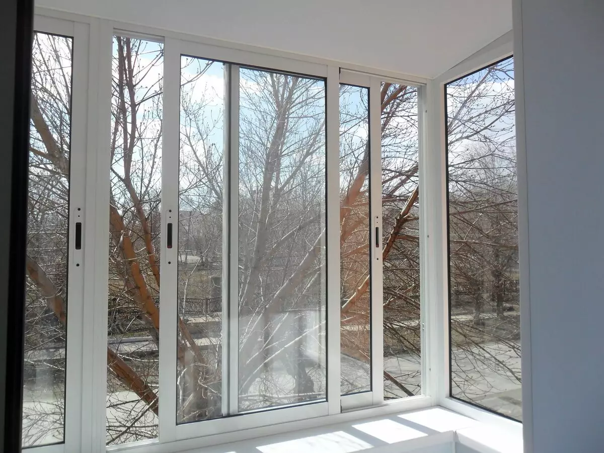 Balkoni kaca oleh profil aluminium (51 foto): Ciri-ciri Balkon Aluminium Bingkai, jenis tingkap kaca yang sejuk dan hangat, sistem cahaya dan bengkak 10026_5