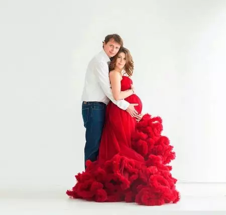 Veshja e bukur me qira për një grua shtatzënë për një xhirim foto