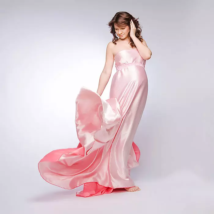 फोटो शुटको लागि एक गर्भवती महिलाको लागि भाँडाको लागि गुलाबी पोशाक