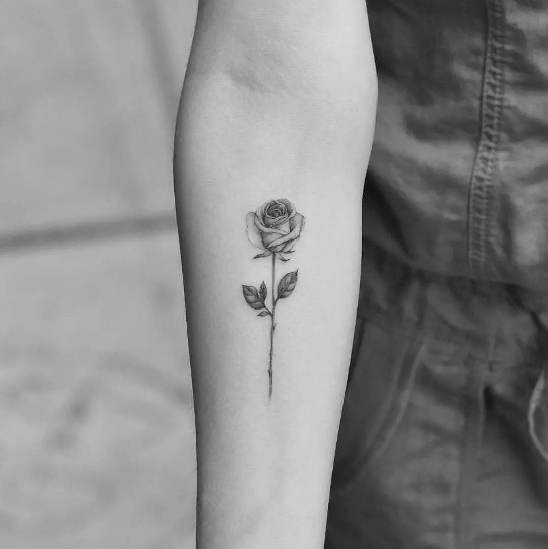 Tattoo Rose za djevojčice (51 fotografije): Vrijednost, tetovaža na ruku i nogu, na zapešću i bedru, skice. Tetovaža na četkima, ramenima i drugim dijelovima tijela 13761_19