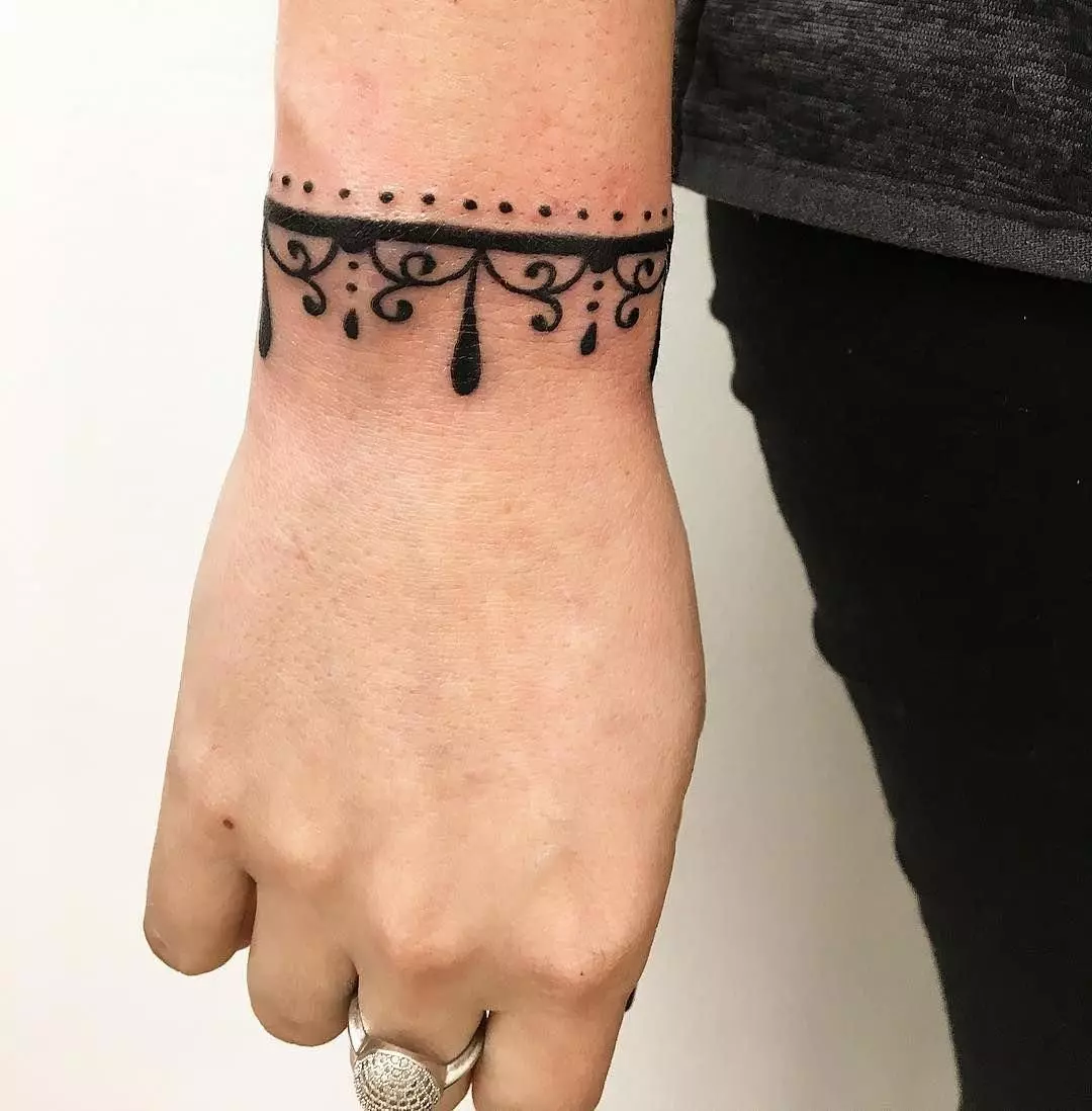Тетоважа во форма на нараквица во рацете на девојки: женски тетоважи на рачниот зглоб и на подлактицата, скици на цвеќиња тетоважа во форма на нараквица и други опции, нивните значења 13770_10