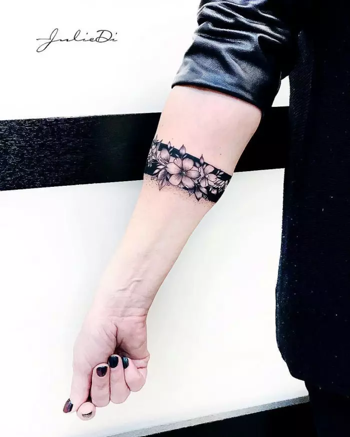 Tato dalam bentuk gelang di tangan gadis: tato wanita di pergelangan tangan dan pada lengan bawah, sketsa tato bunga dalam bentuk gelang dan pilihan lainnya, artinya 13770_11