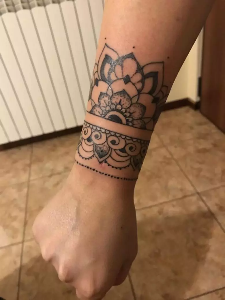 Tato dalam bentuk gelang di tangan gadis: tato wanita di pergelangan tangan dan pada lengan bawah, sketsa tato bunga dalam bentuk gelang dan pilihan lainnya, artinya 13770_12