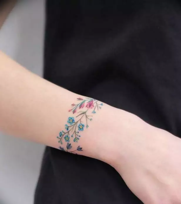 Tatuaxe en forma de pulseira en mans de nenas: tatuajes femininas sobre o pulso e no antebrazo, os bocetos de tatuaxe de flores en forma de pulseira e outras opcións, os seus significados 13770_15