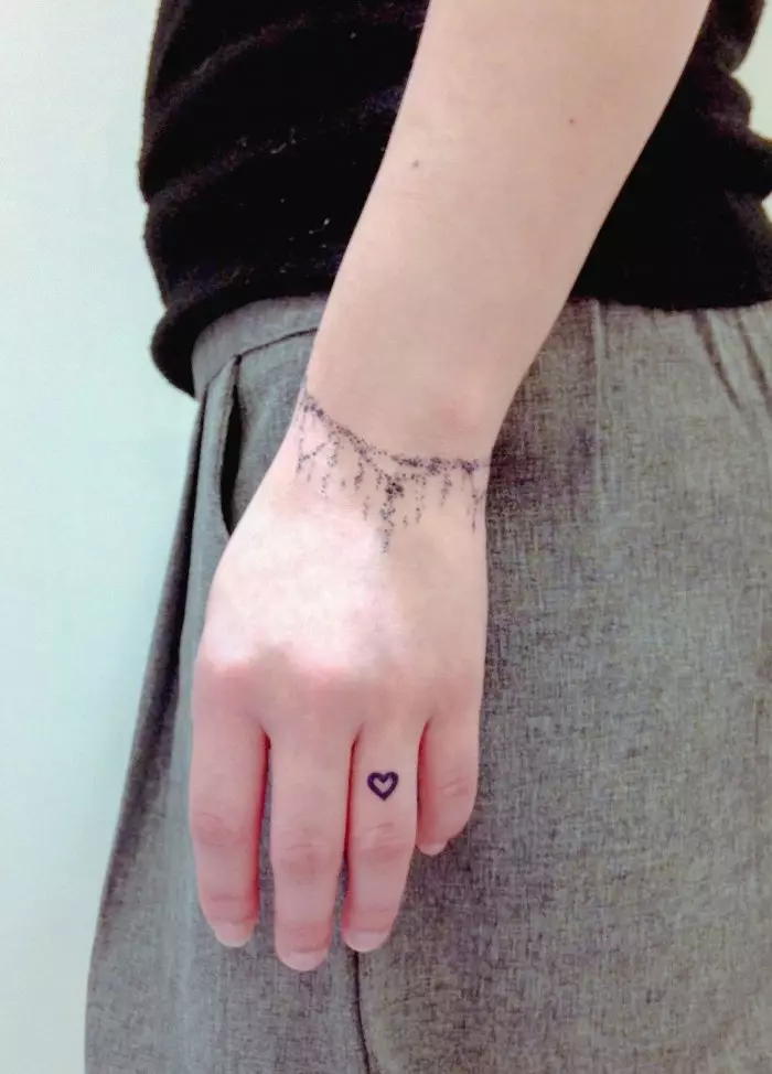 Tatuaxe en forma de pulseira en mans de nenas: tatuajes femininas sobre o pulso e no antebrazo, os bocetos de tatuaxe de flores en forma de pulseira e outras opcións, os seus significados 13770_17