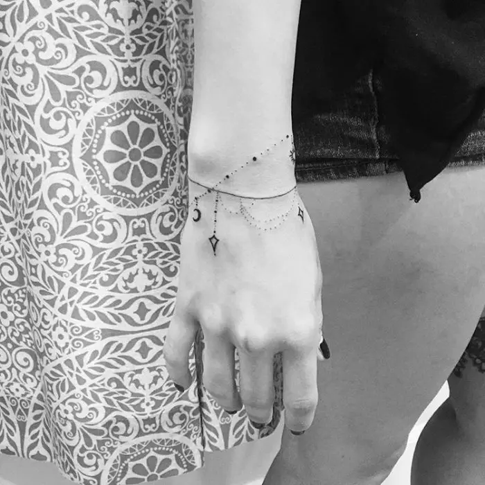 Tatu dalam bentuk gelang di tangan gadis-gadis: tatu wanita di pergelangan tangan dan di lengan bawah, lakaran bunga tatu dalam bentuk gelang dan pilihan lain, makna mereka 13770_49