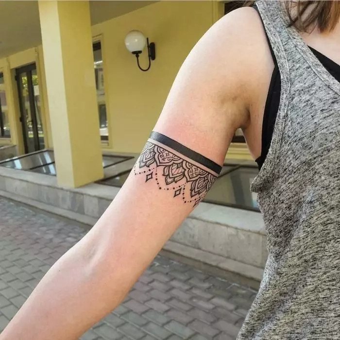 Tatuaxe en forma de pulseira en mans de nenas: tatuajes femininas sobre o pulso e no antebrazo, os bocetos de tatuaxe de flores en forma de pulseira e outras opcións, os seus significados 13770_55