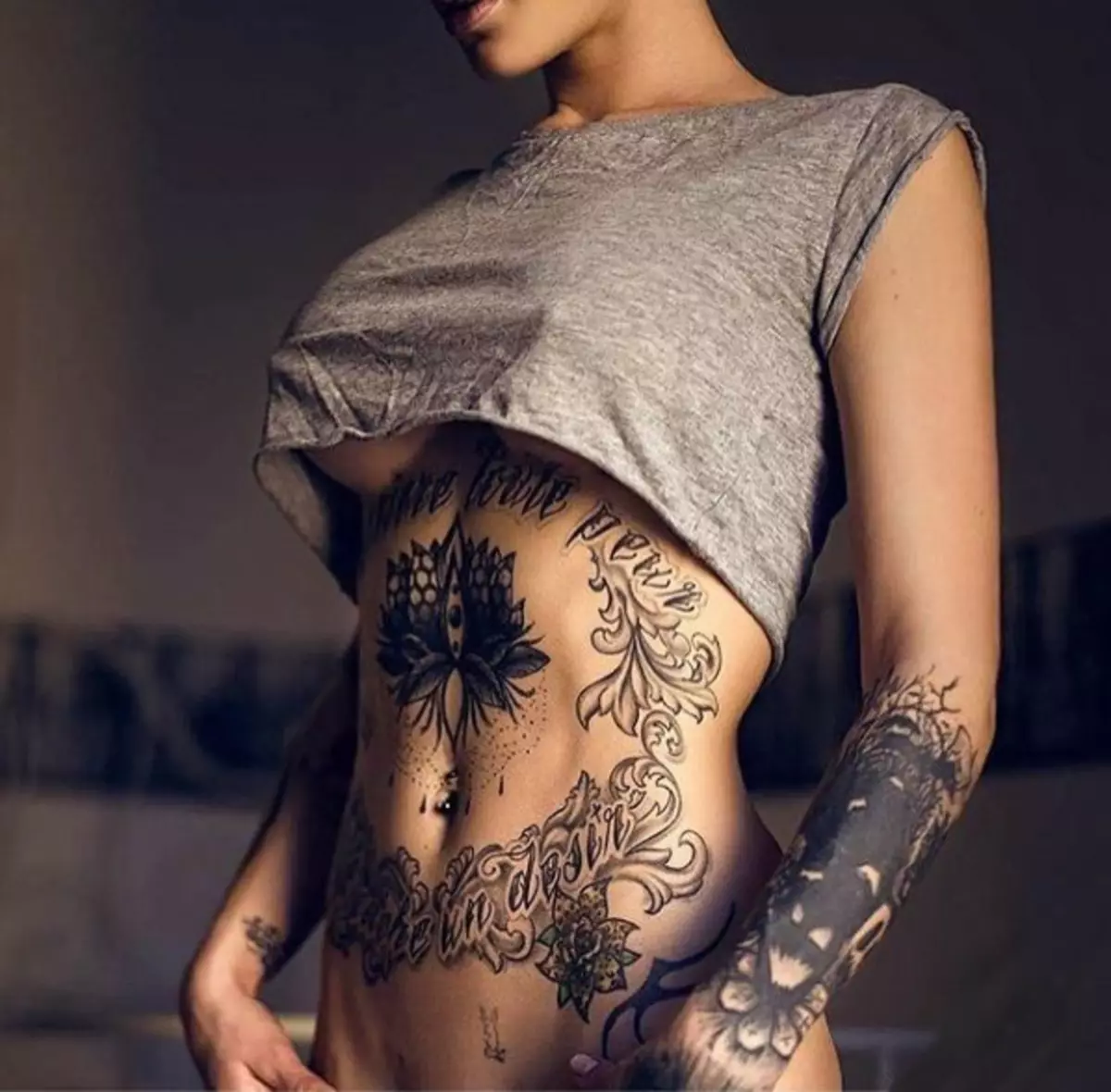 Tattoo në stomak për vajzat (61 foto): skica. Tatuazhe në pjesën e poshtme të barkut dhe rreth kërthizës pas lindjes, tatuazh të vogël të bukur dhe të mëdha 13772_11