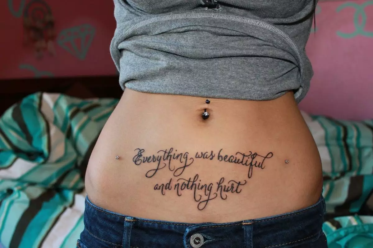 Tattoo ar an boilg (50 grianghraf): Ar an navel, ar an bpreas agus an bolg ag an mbun. Sceitsí de thattoos álainn. Figiúirí Tattoo 1999 agus 2002, 1998 agus daoine eile, roghanna eile le haghaidh íomhánna beaga agus móra 13790_14