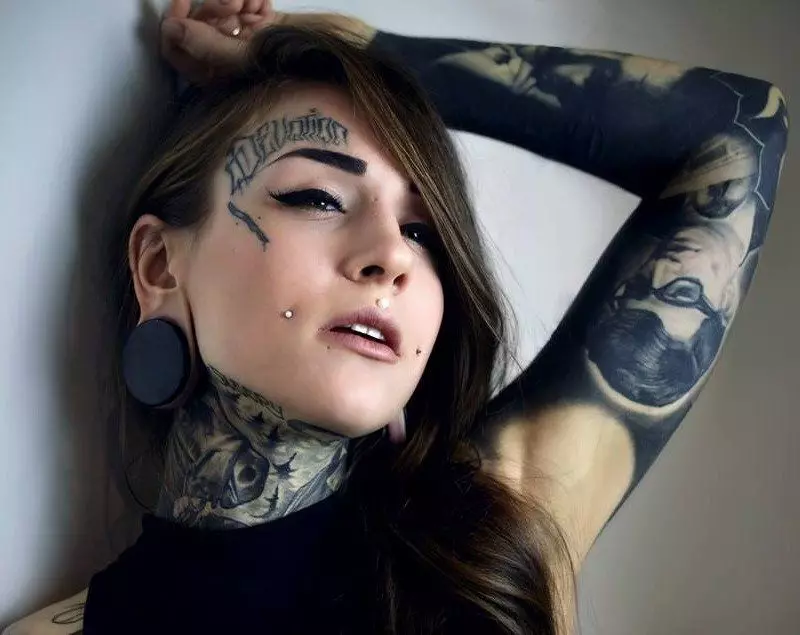 Tatuaje aurpegian (57 argazki): neskentzako eta gizonentzat, tatuaje txikien zirriborroak eta handiak. Tatuaje kopetan eta bekain gainean, masailean eta aurpegiko beste leku batzuetan 13818_26
