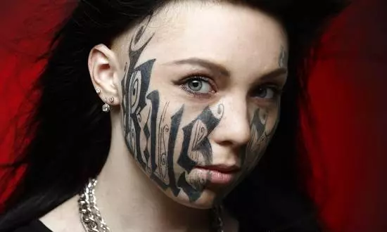 Tatuatge a la cara (57 fotos): Per a noies i homes, esbossos de tatuatges petits i grans. Tatuatge al front i sobre les celles, a la galta i en altres parts de la cara 13818_45