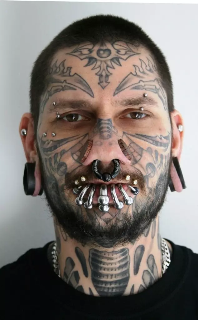 Tatuatge a la cara (57 fotos): Per a noies i homes, esbossos de tatuatges petits i grans. Tatuatge al front i sobre les celles, a la galta i en altres parts de la cara 13818_7