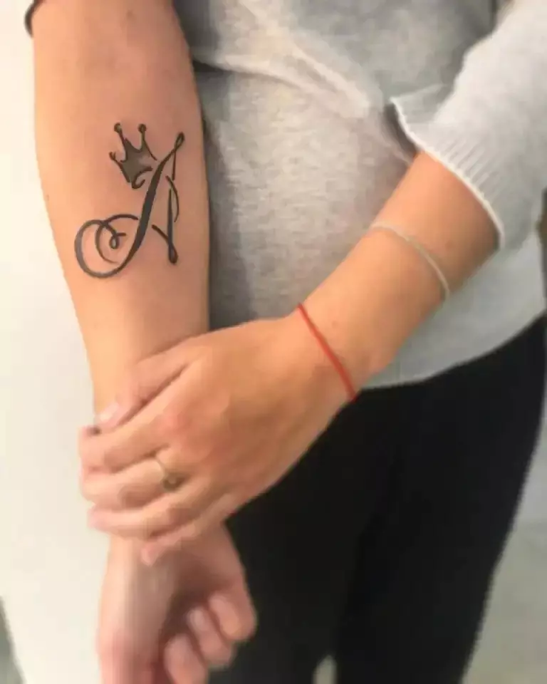 Τατουάζ με τη μορφή του γράμματος «Α»: στον καρπό στο χέρι και επί των νευρώσεων. Γράμμα «Α» με όμορφη γραμματοσειρά σε ένα κύκλο, αναστρέφεται και άλλες επιλογές, οι τιμές των τατουάζ 13893_2