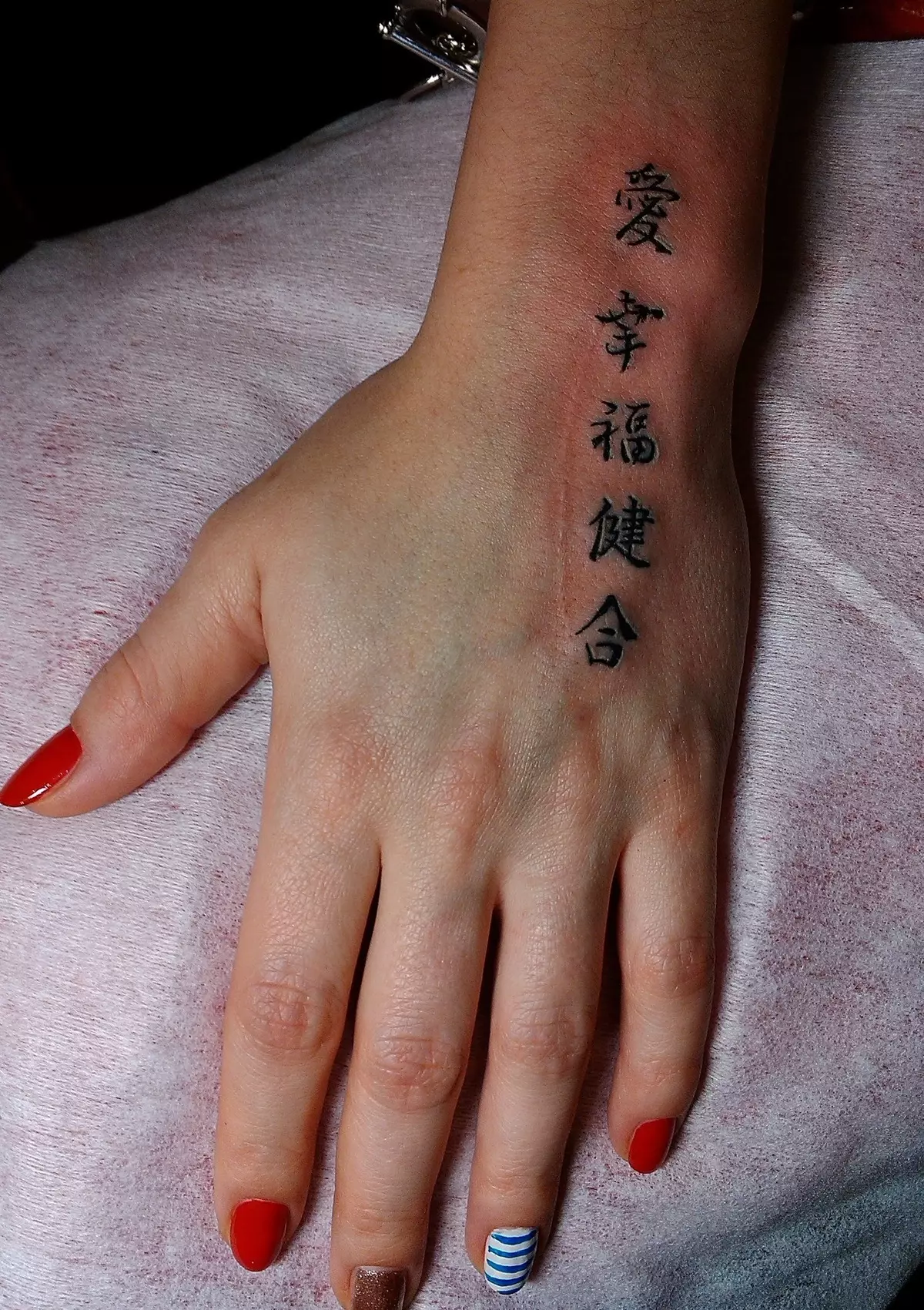 Tetovaža na ruci (66 fotografija): skice, male pluća i velika tetovaža. Jednostavne kaste i prekrasne zvijezde, osmijeh i cvijeće, kartice i druge ideje 13913_31
