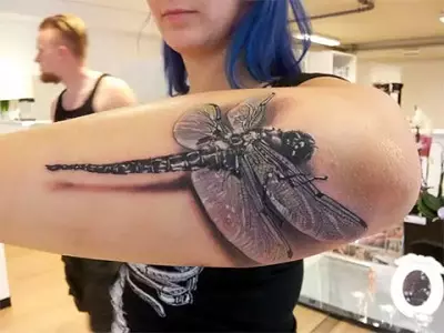 Tattoo med dragonfly (47 bilder): Värdet av tatueringar för tjejer och för män, skisser av mini-tatuering och stor, tatuering på handleden och på baksidan, på axeln och på andra delar av kroppen 13916_22