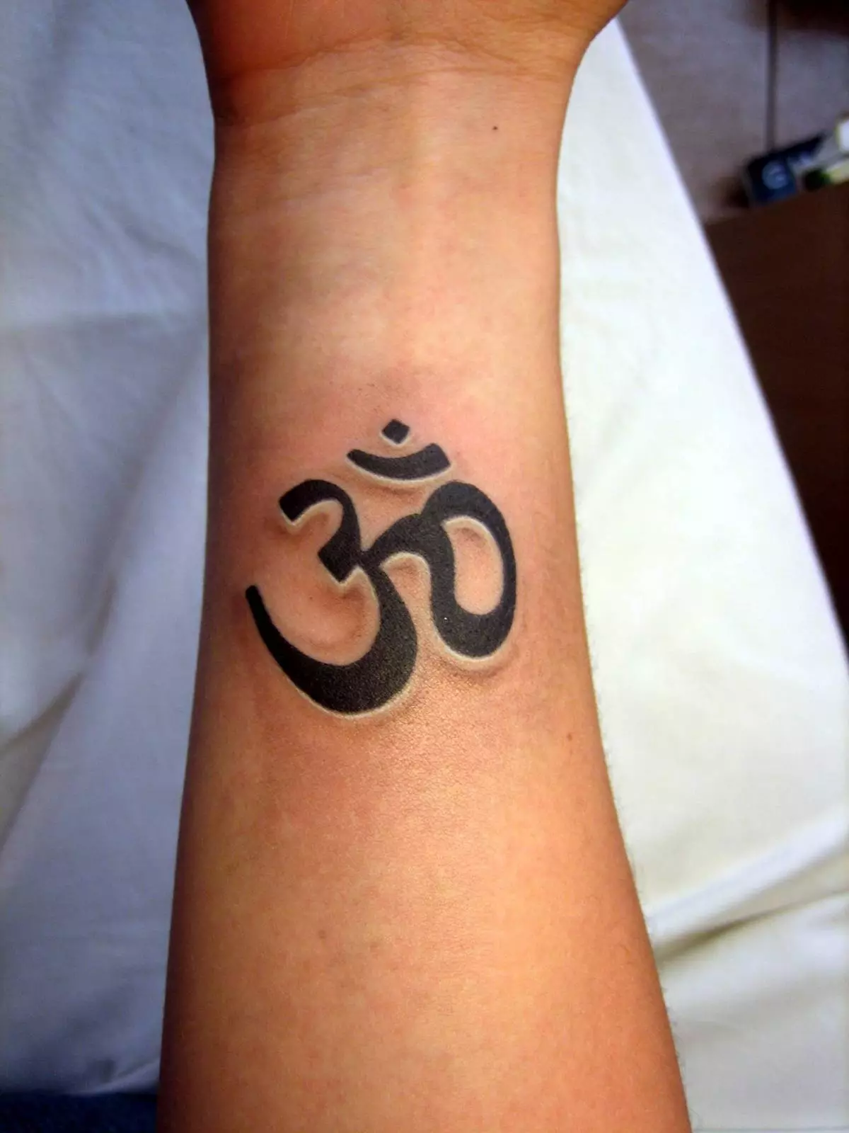 Om tattoo: agaciro ka tatouage muburyo bwikimenyetso cya mantra, tatouage ku ijosi no inyuma, ku rutugu hamwe n'ibindi bice by'umubiri, ibishushanyo 13932_20