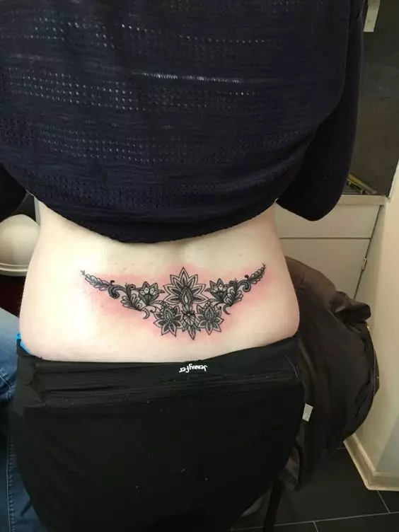 Tetoválás az alsó hátán (54 fotók): Gyönyörű tetoválás vázlata, kicsi és nagy. Hogy érted? Divatos és szokatlan tetoválás, szerelmesek, csillagok és mások 13938_32