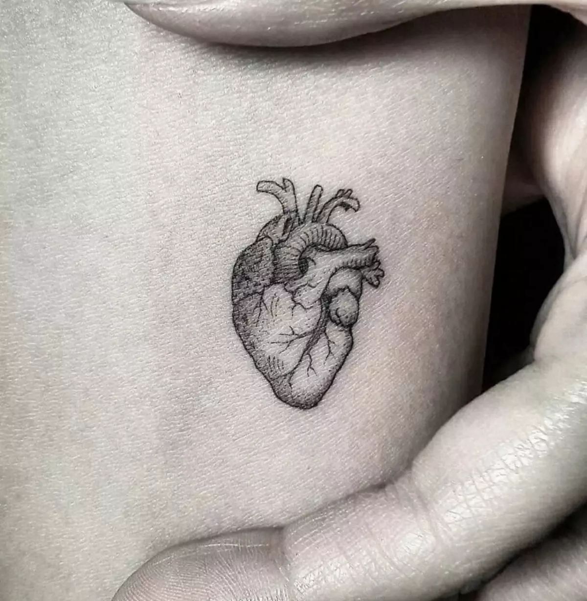 tattoo ໃນຮູບແບບຂອງຫົວໃຈ (41 Photos): sketches ຂອງ tattoos ແລະຄວາມຫມາຍ. Tattoo ຢູ່ໃນຂໍ້ມືຢູ່ໃນມືແລະສ່ວນອື່ນໆຂອງຮ່າງກາຍ. ຫົວໃຈຫັກນ້ອຍແລະຕົວເລືອກອື່ນໆ 14022_36