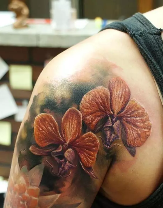 Tattoo ine orchids (57 photos): tattoo kukosha kwevasikana, sketch kuongorora. Tattoo paruoko uye gumbo, pane clavicle uye kumashure, pafudzi uye pane dzimwe nhengo dzemuviri 14034_11
