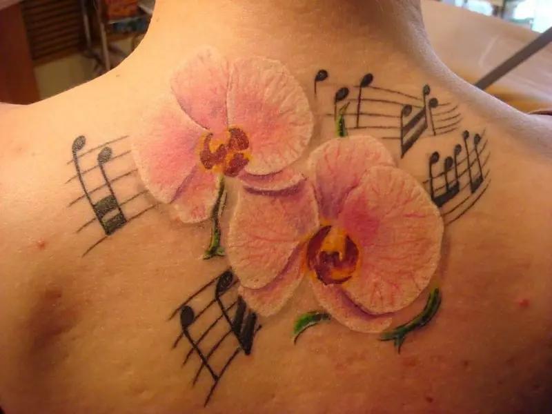 Tattoo ine orchids (57 photos): tattoo kukosha kwevasikana, sketch kuongorora. Tattoo paruoko uye gumbo, pane clavicle uye kumashure, pafudzi uye pane dzimwe nhengo dzemuviri 14034_6