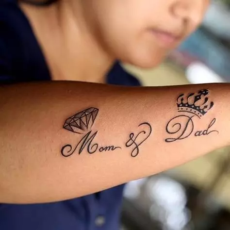 Tetovaža s imenima (57 fotografija): tetovaže na ruci na zapešću i na prstu, skice nominalne tetovaže za djevojčice i muškarce. Lijepa tetovaža i druge opcije 14047_16