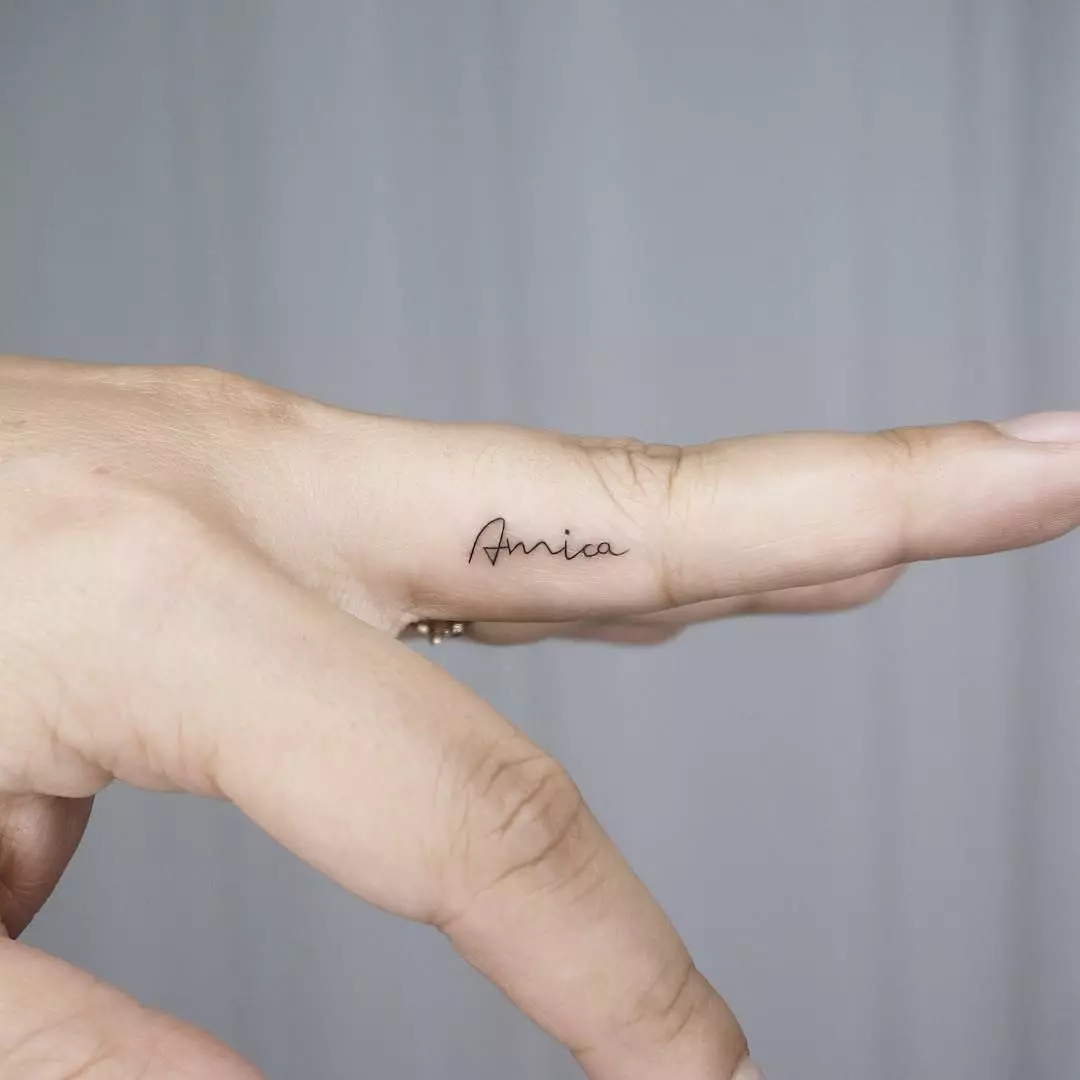 Tatouage avec noms (57 photos): tatouages ​​sur la main sur le poignet et au doigt, des croquis du tatouage nominal pour les filles et pour les hommes. Belle tatouage et autres options 14047_43