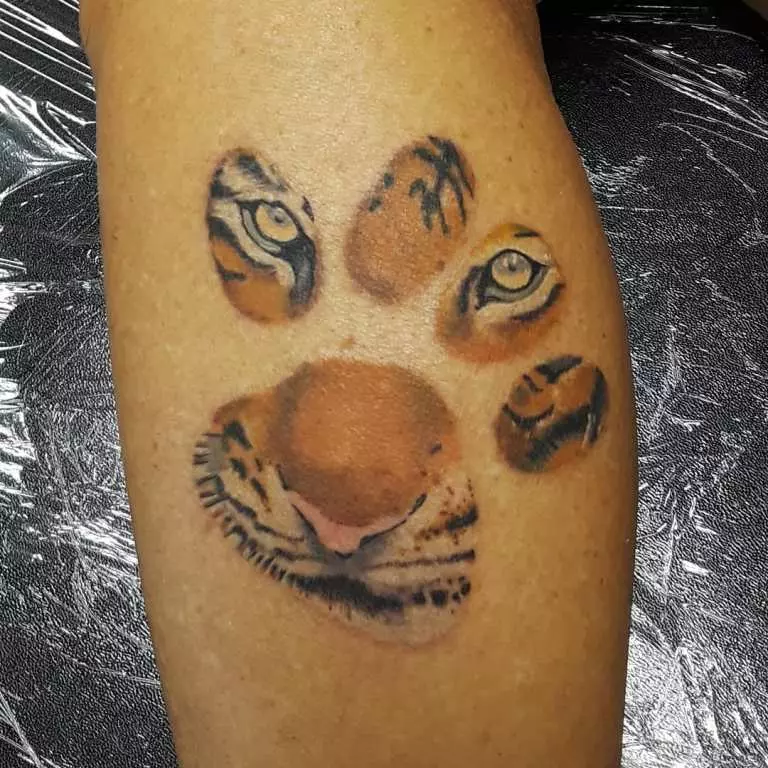Tattoo cu tigru pentru fete (34 fotografii): Semnificație și schițe. Tiger Tiger la îndemână și pe coapsă, pe picior și pe spate, pe încheietura mâinii și pe umăr 14119_12