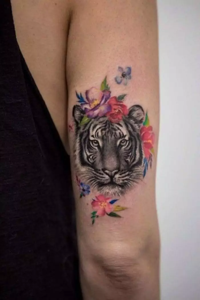 Тетоважа со тигар за девојки (34 фотографии): Значење и скици. Тетоважа тигар при рака и на бутот, на нога и на грб, на рачниот зглоб и на рамо 14119_29