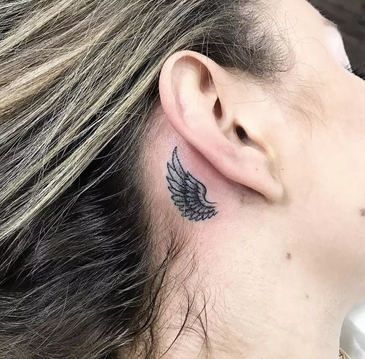 Tatuatge darrere de l'orella per a les nenes (39 fotos): esbossos de tatuatges petits, el valor de mini-tatuatge de les dones, els tatuatges amb estrelles i inscripcions, serps i plomes, altres opcions 14190_34