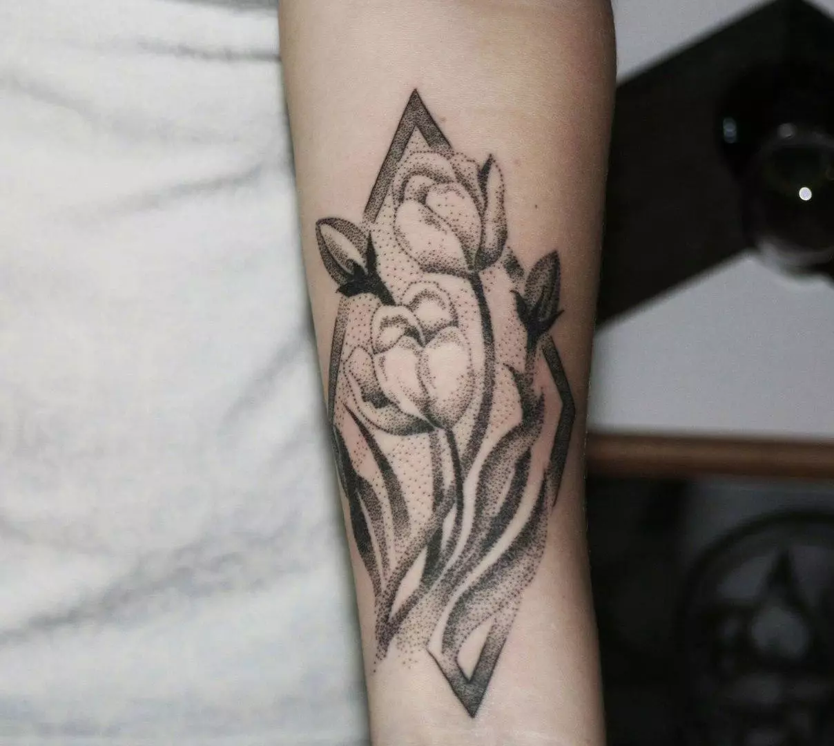 Tattoo ດ້ວຍດອກທິວລິບ: ມູນຄ່າຂອງ tattoos ສໍາລັບເດັກຍິງແລະສໍາລັບຜູ້ຊາຍ, sketches ໄດ້. Tattoo ໃນອີກດ້ານກ່ຽວກັບການ wrist ແລະໃນພື້ນທີ່ອື່ນໆ, tulip ສີດໍາແລະທາງເລືອກອື່ນ 14192_11