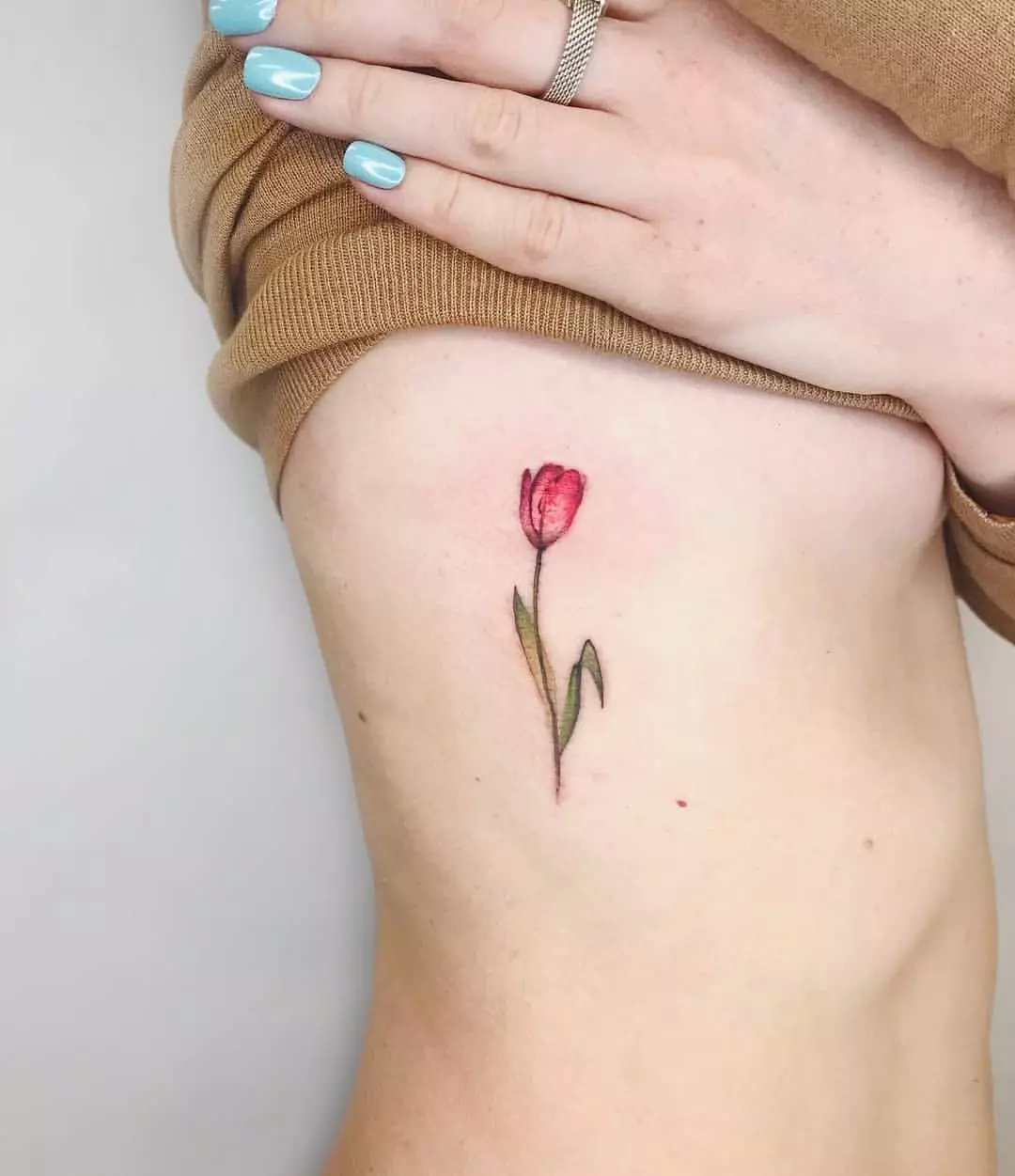 Tato dengan tulip: nilai tato untuk anak perempuan dan untuk pria, sketsa. Tato di tangan pergelangan tangan dan di daerah lain, tulip hitam dan opsi lainnya 14192_5