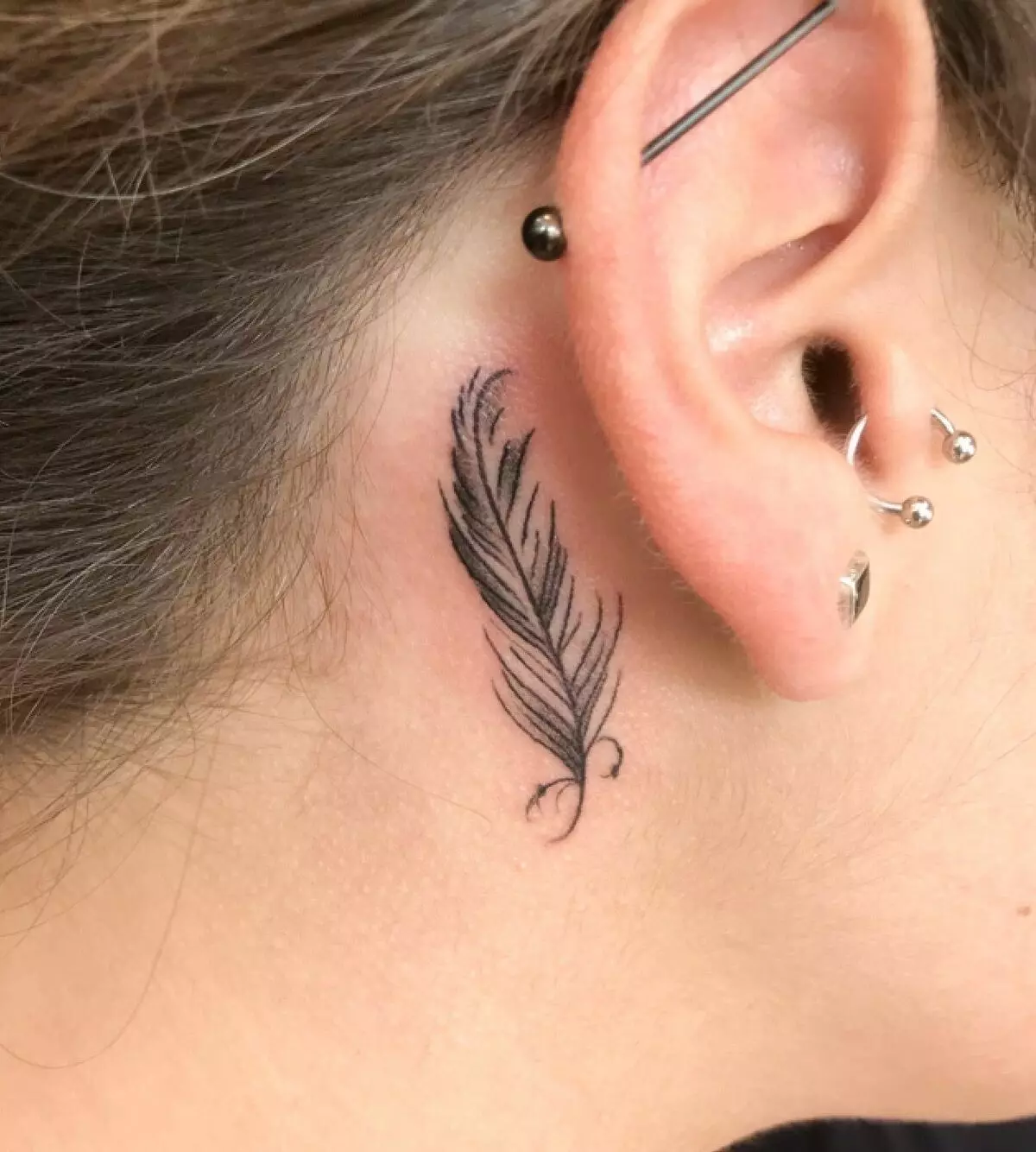 Tetovaža uha (58 fotografija): tetovaže za muškarce i za žene, male zvijezde i zmije, ptice i grančice, zvjezdice i feniks, druge opcije i primjeri skica 14236_43