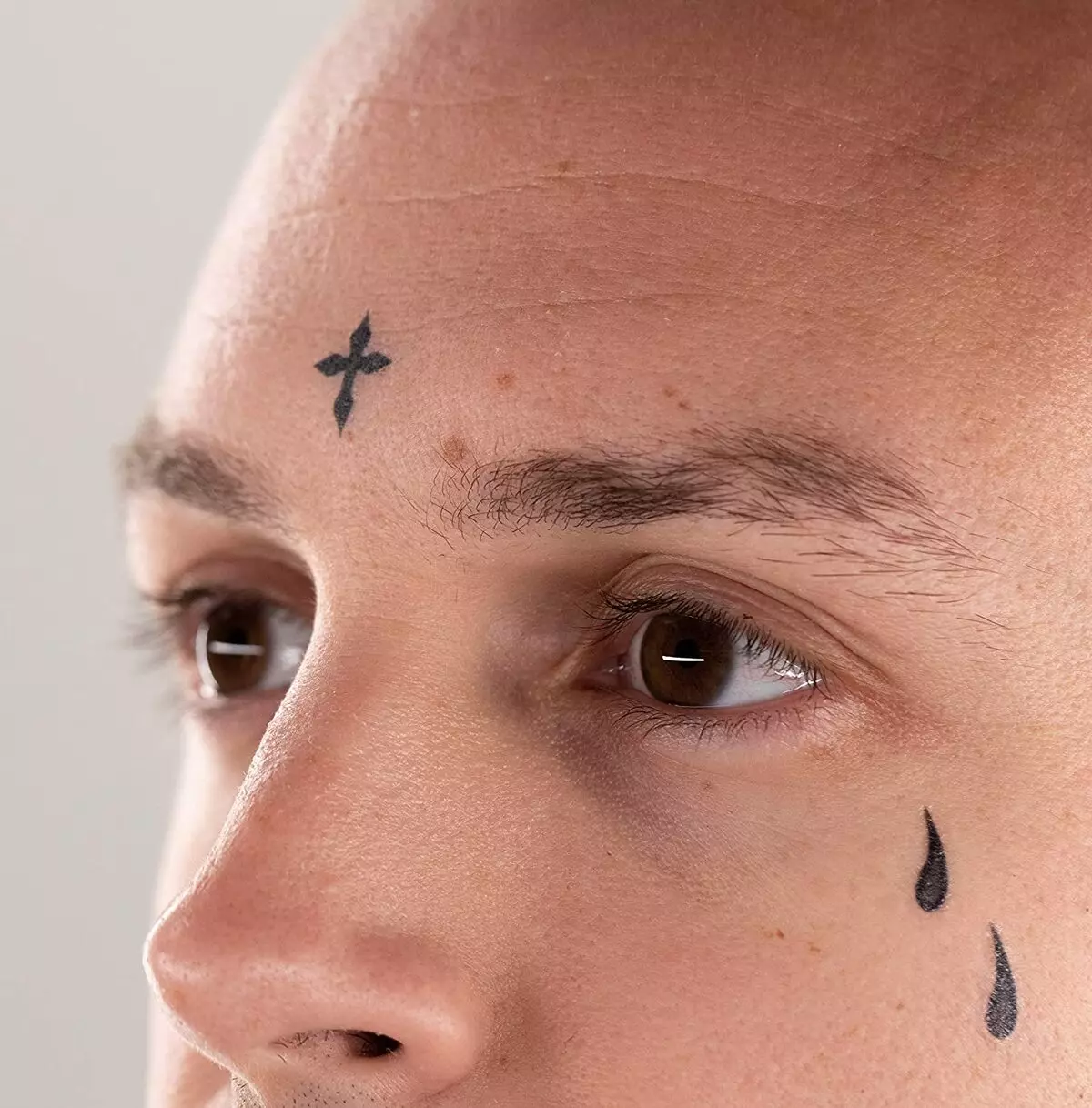 Tatuazh i përkthyer (45 foto): Si të ngjitni tatuazhet e përkohshme në trup? Tattooo-freckles në fytyrë dhe tatuazh të tjera që mbajnë për një kohë të gjatë 14269_38