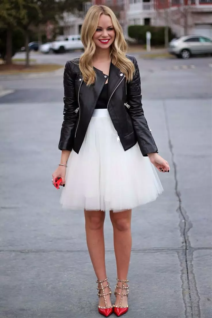 Fusta albă multistrat în combinație cu o jachetă neagră și pantofi roșii straini