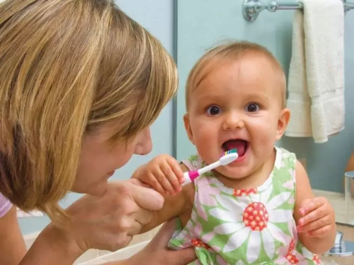 Hoe om tande te borsel aan kinders? Sorg vir die eerste tande in die baba tot die jaar, die tande skoonmaak tegniek in die baba in 2 jaar, die reëls vir die ander ouderdom. Hoeveel tyd het jy nodig om jou tande te borsel? 16141_5
