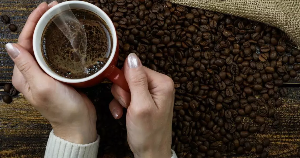 Kaffe som gave (27 billeder): Hvordan man giver kaffesætet original? Sådan smukt pakker dåsen af ​​opløselige kaffe eller kaffebønner med et krus og en ske? Hvordan laver man en kaffebuket? 18796_6