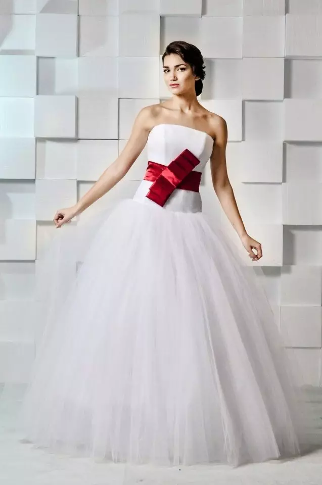 Vestuvių suknelė su raudonu lanku susieta viduryje