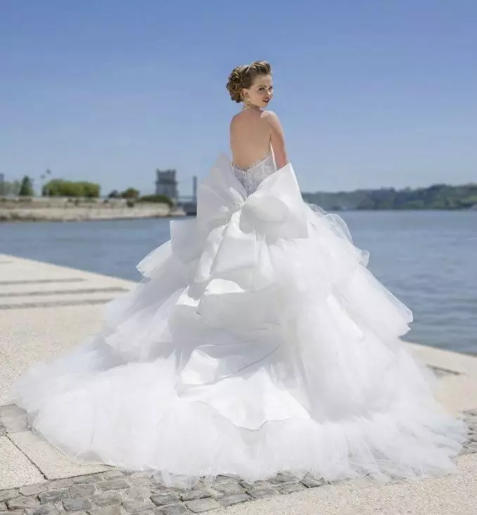Vestido de novia exuberante con una falda en cascada y un bucle