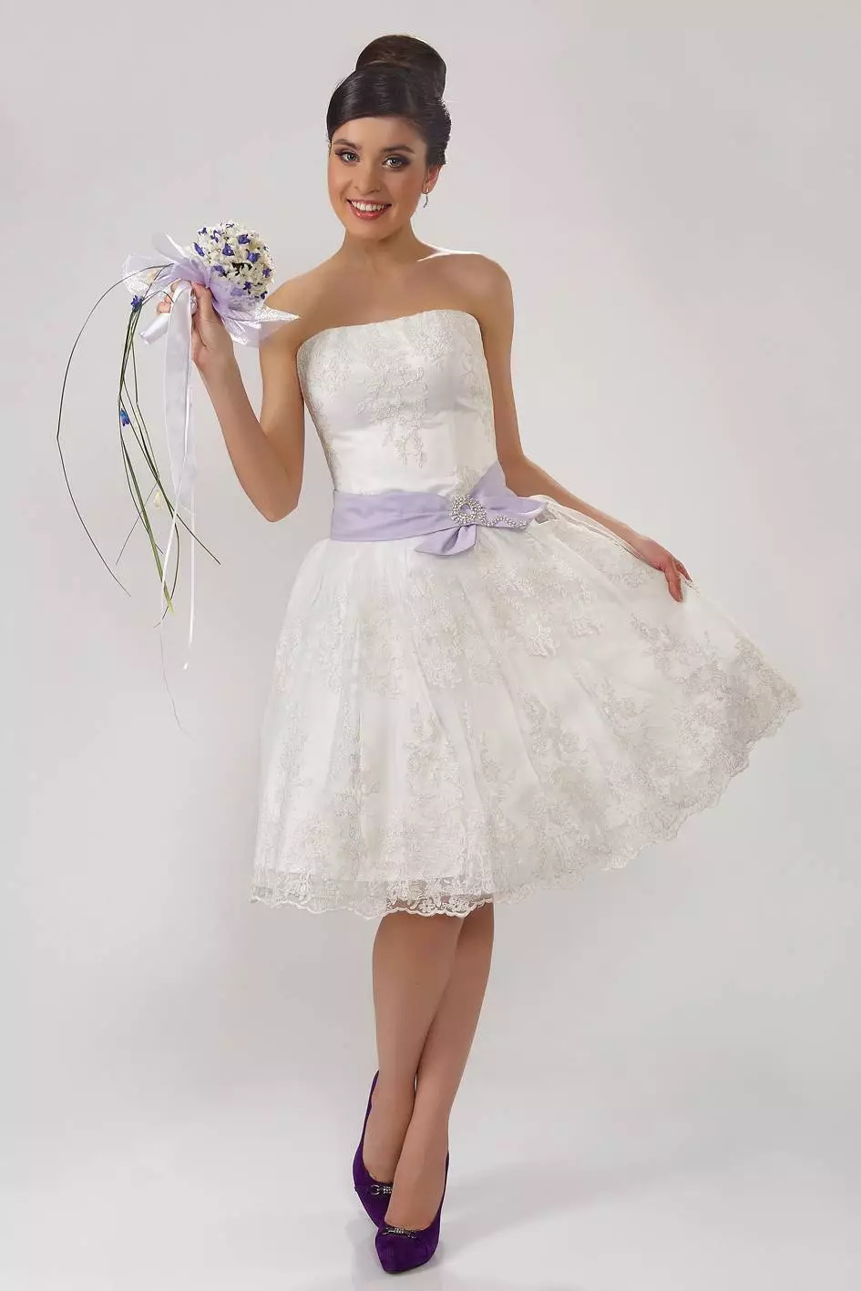 鞋带婚礼礼服的新娘与明亮的花束