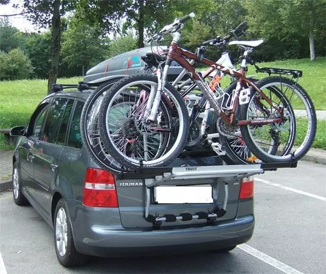 Tronc de bicicletes a la porta del darrere del cotxe: Característiques de Cybaggets per al cotxe, els pros i els contres del cicloturisme. Com triar una fixació per transportar un cotxe de bicicleta? 20483_10
