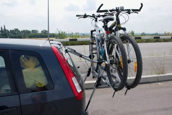 Tronc de bicicletes a la porta del darrere del cotxe: Característiques de Cybaggets per al cotxe, els pros i els contres del cicloturisme. Com triar una fixació per transportar un cotxe de bicicleta? 20483_20