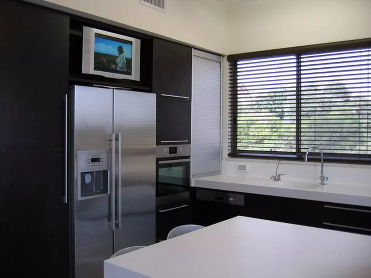 Opcions d'allotjament de la televisió de cuina (56 fotos): instal·lació en els auriculars de la cuina, opcions de disseny de cuina. Com penjar la televisió sobre la taula? 20943_31