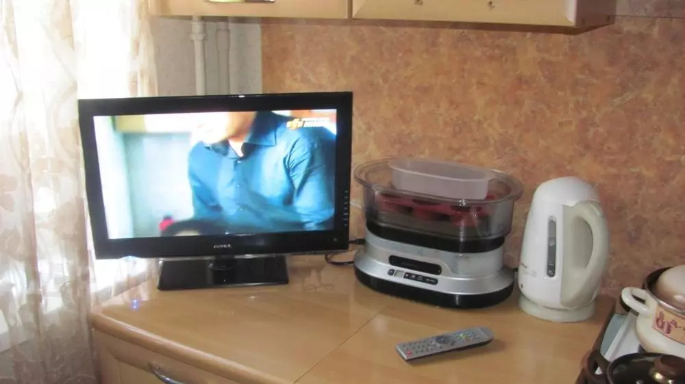 Opcions d'allotjament de la televisió de cuina (56 fotos): instal·lació en els auriculars de la cuina, opcions de disseny de cuina. Com penjar la televisió sobre la taula? 20943_47