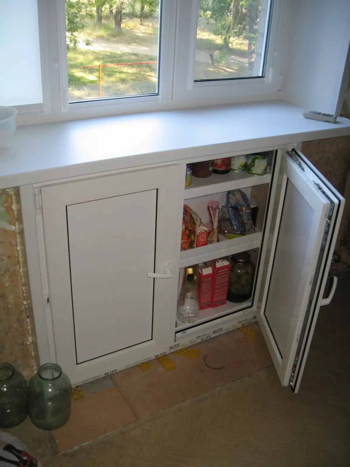 Niša u kuhinji ispod prozora (38 slike): Zima kabinet hladnjak i kutiju ispod prozora u kuhinji, police i druge opcije završne obrade dizajn 20962_6