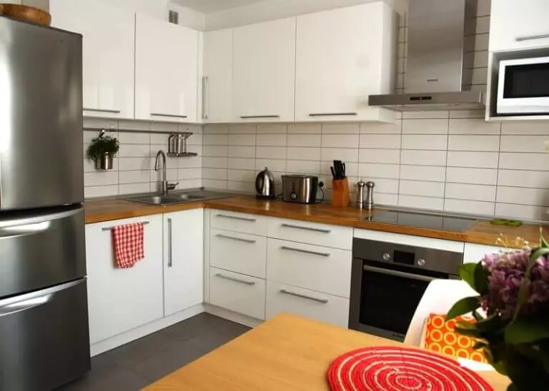 Bucătăriile unghiulare albe (46 fotografii): căști de bucătărie lucioasă și mată în stilul interior, modern și clasic, din MDF și plastic 21179_19