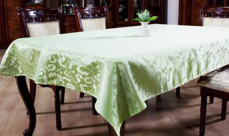 Taplak meja hijau: taplak meja monofonik hijau gelap di atas meja dan kelabu-hijau, pengaturan pengaturan. Linen dan Jacquard, taplak meja oval dan bundar di interior 21601_10