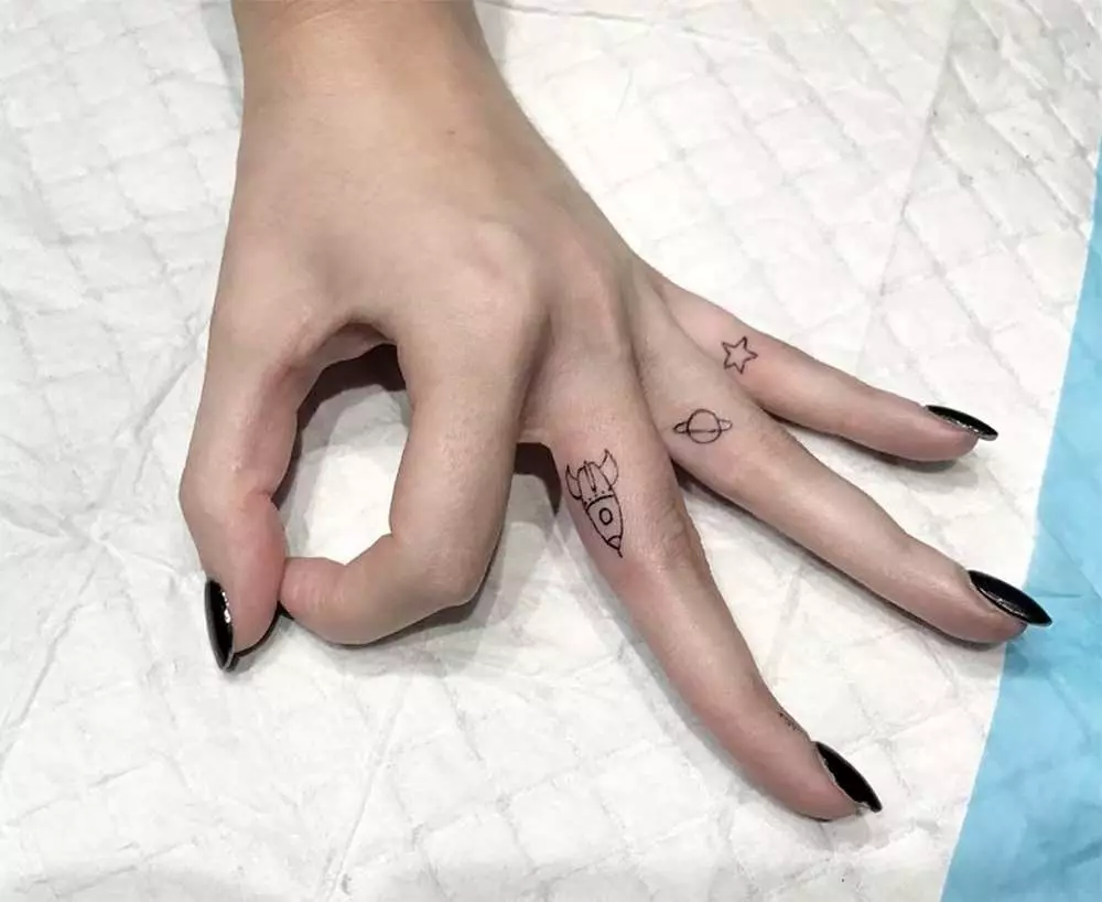Tatuering på fingrarna för tjejer (68 bilder): kvinnliga små tatueringar och deras skisser. Mini-tatuering på sidan av det namnlösa fingret och på den stora, på Maizin-källan och på de andra fingrarna 247_13