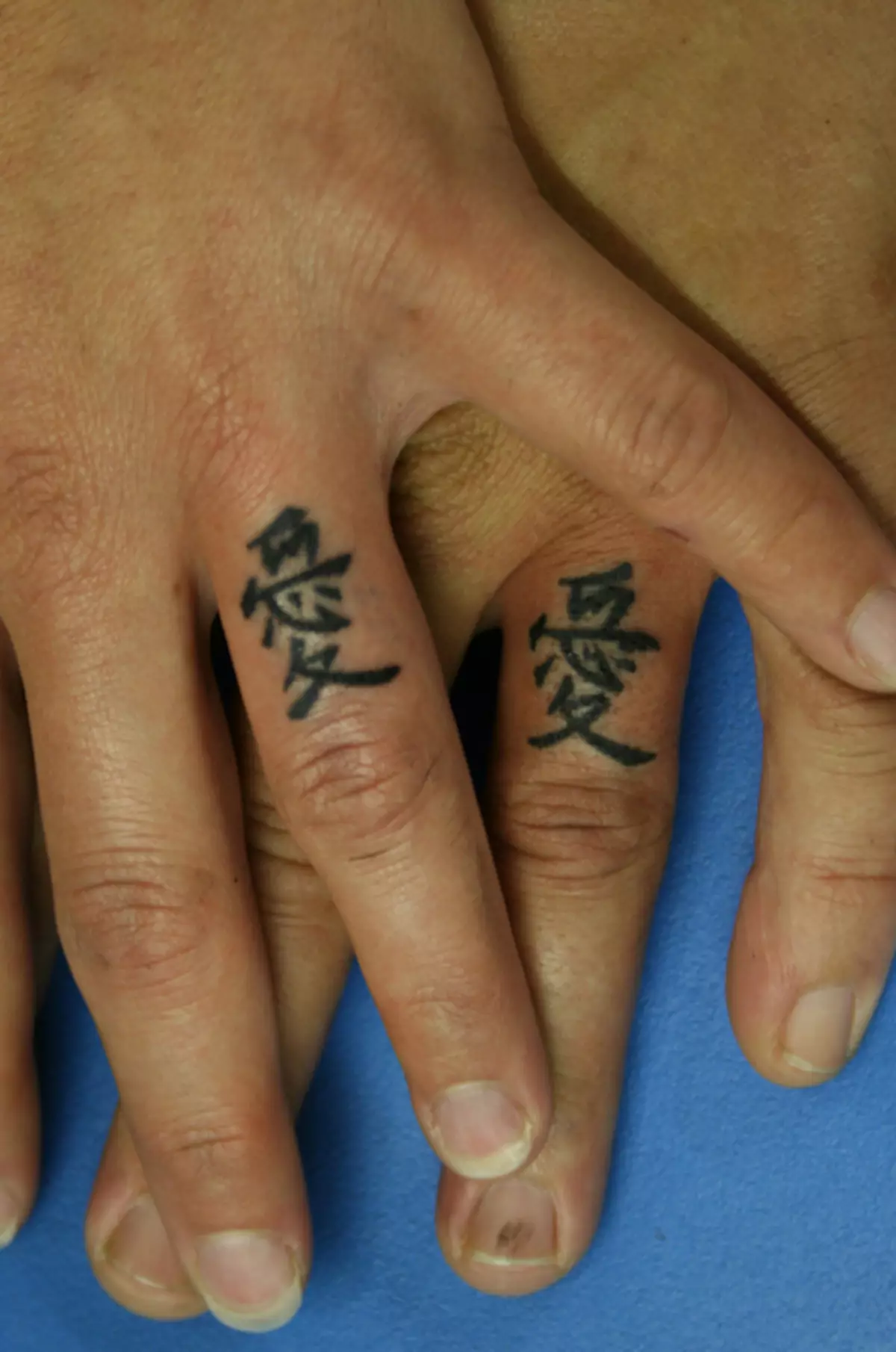 Tatuering på fingrarna för tjejer (68 bilder): kvinnliga små tatueringar och deras skisser. Mini-tatuering på sidan av det namnlösa fingret och på den stora, på Maizin-källan och på de andra fingrarna 247_15