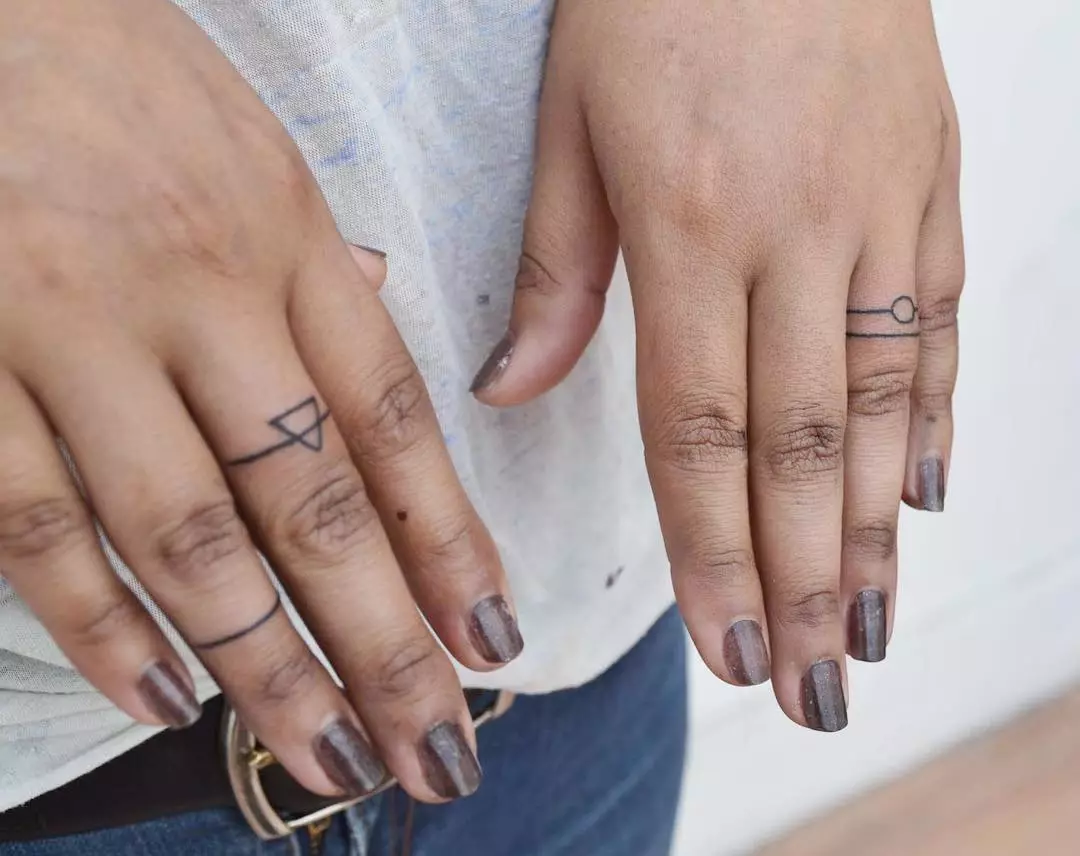 Tattoo op de vingers voor meisjes (68 foto's): vrouwelijke kleine tatoeages en hun schetsen. Mini-tattoo aan de zijkant van de naamloze vinger en op de grote, op de Maizin-kerel en op de andere vingers 247_22